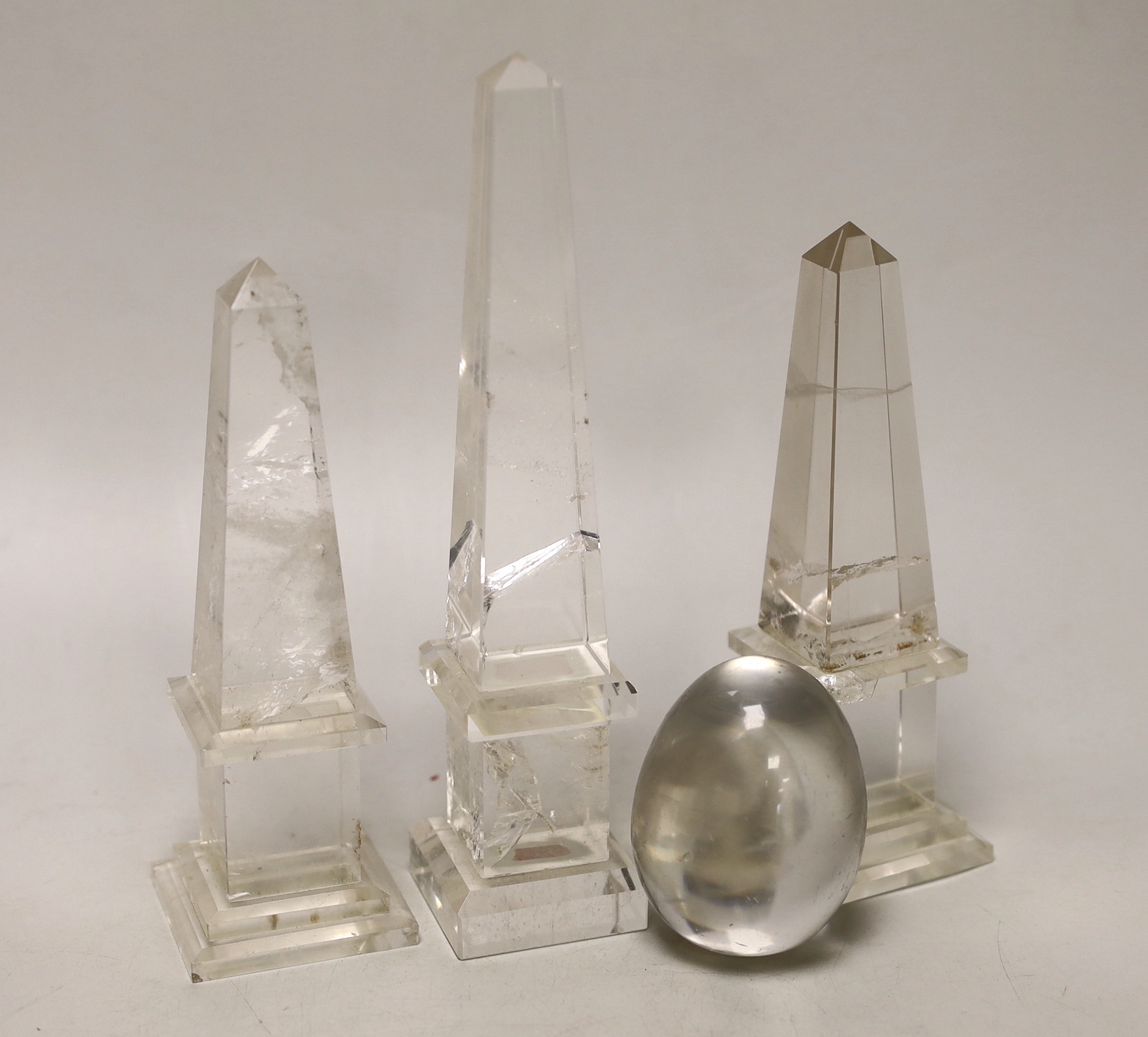 A pair of rock crystal obelisks, a taller obelisk and an egg, tallest 20cm high